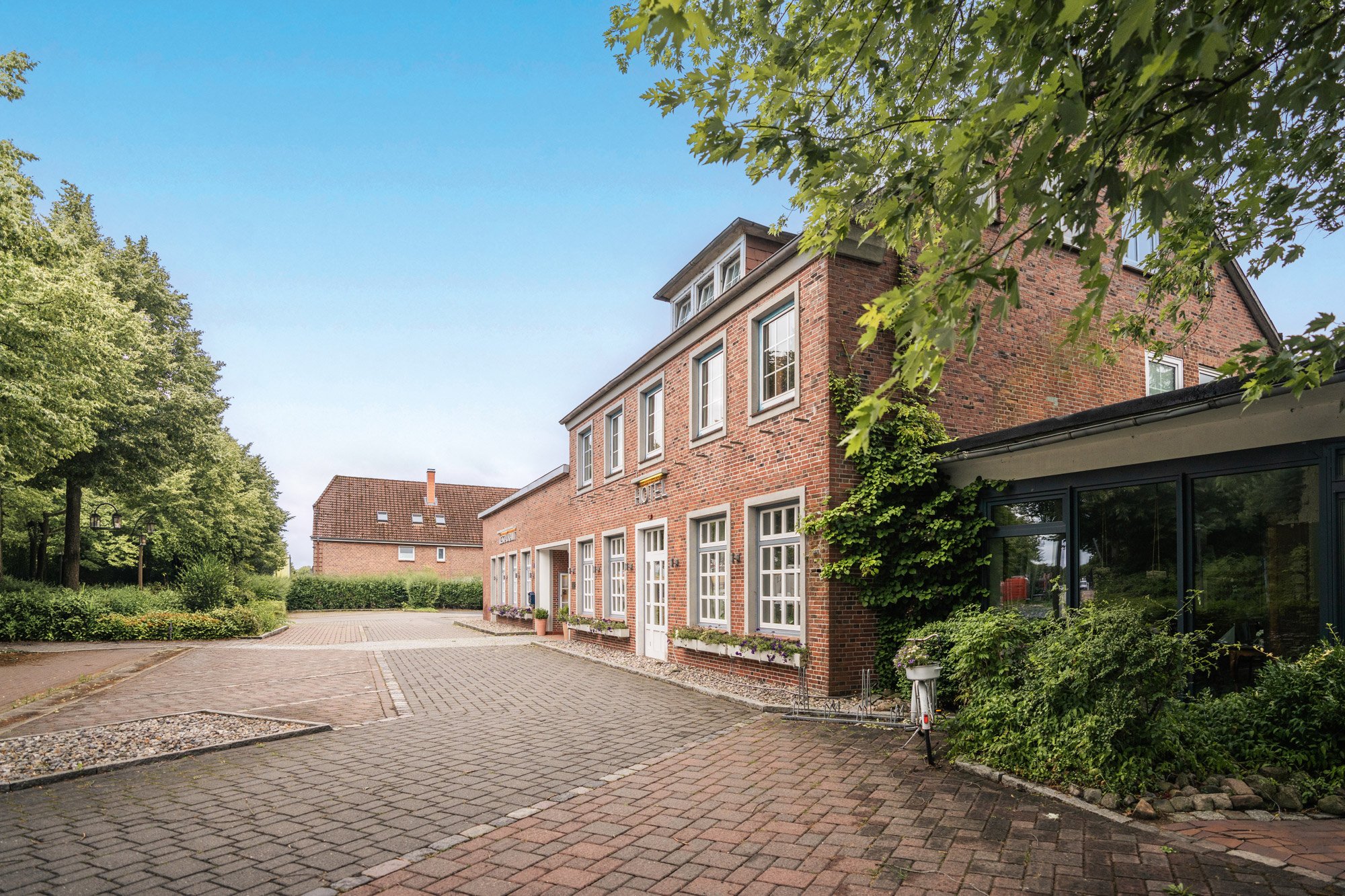 Außenansicht des Hotels Wistedter Hof mit gepflastertem Vorplatz
