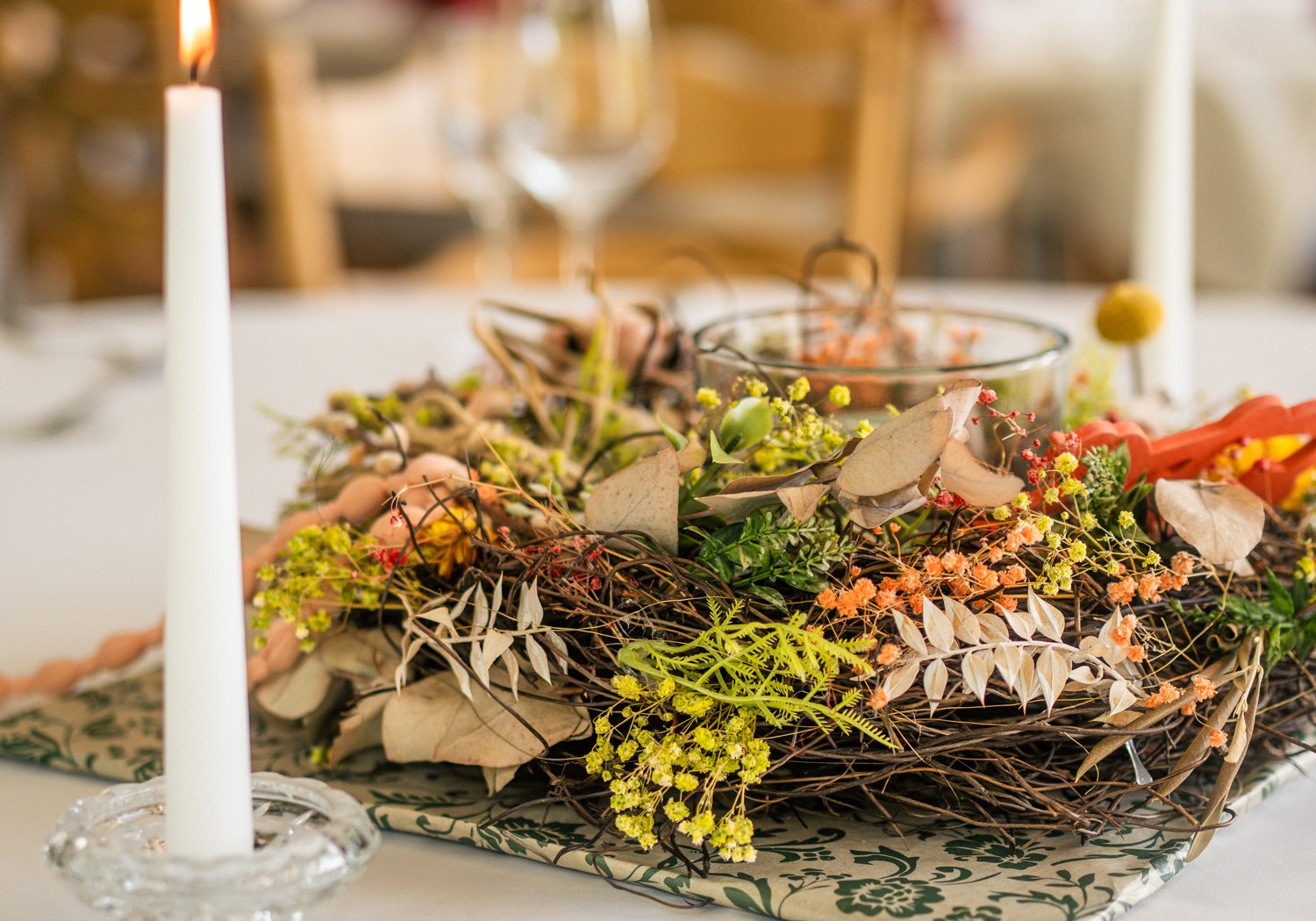 Tischdekoration mit Blättern, Blüten und Kerzen