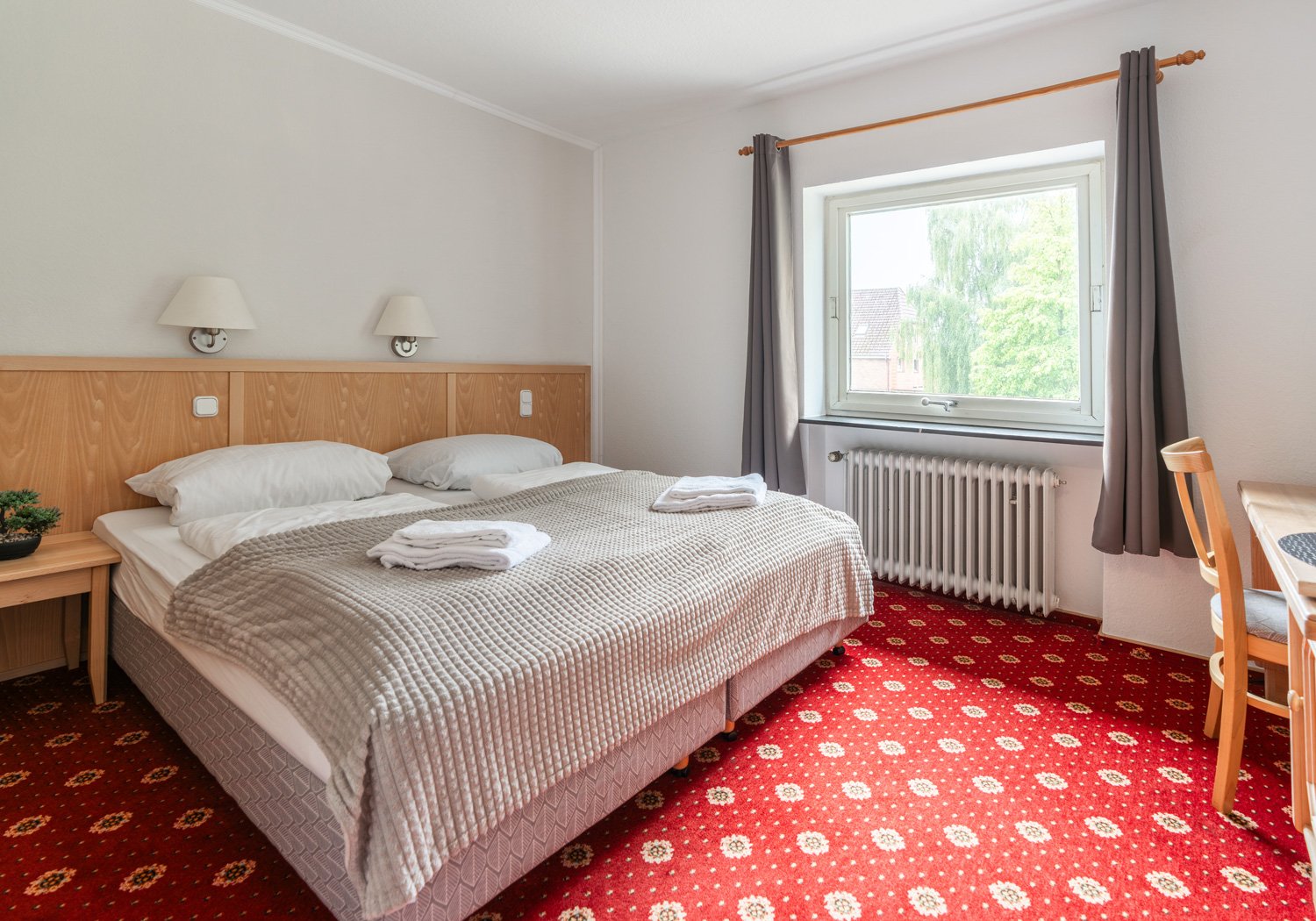Doppelzimmer mit großem Fenster und Schreibtisch