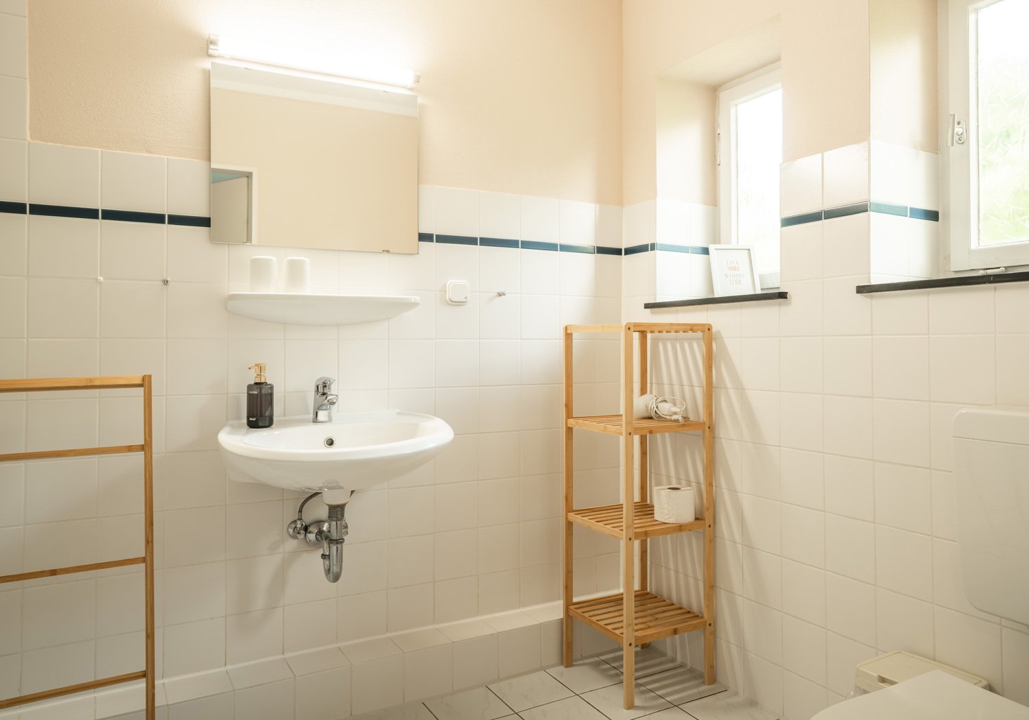 Helles Badezimmer mit Spiegel und Holzregal
