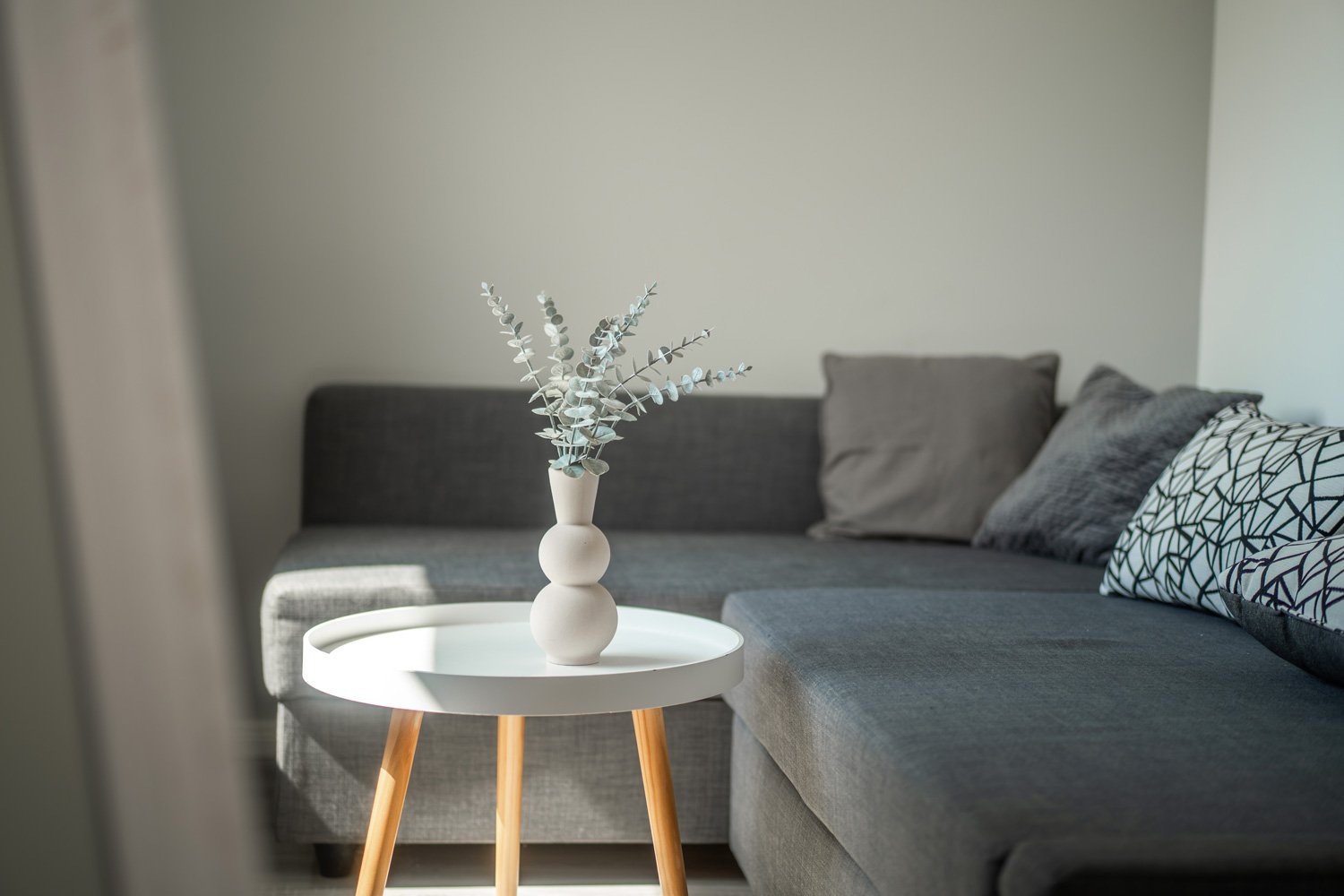 Sitzecke mit grauem Sofa und rundem Beistelltisch