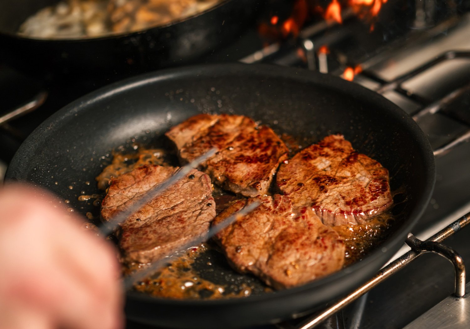 Fleischstücke beim Braten in der Pfanne